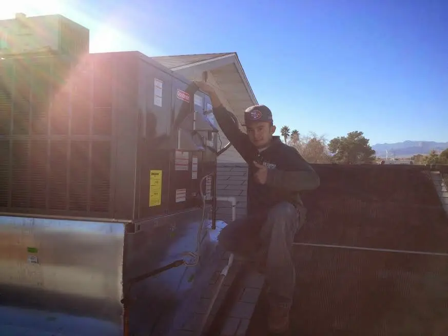 HVAC technician performing Air Duct Repair on a rooftop unit in Ben Lomond